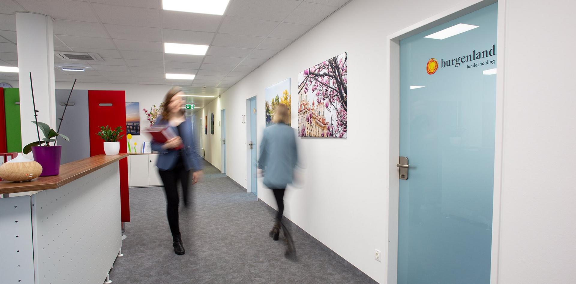 zwei Frauen gehen in einem Bürogang